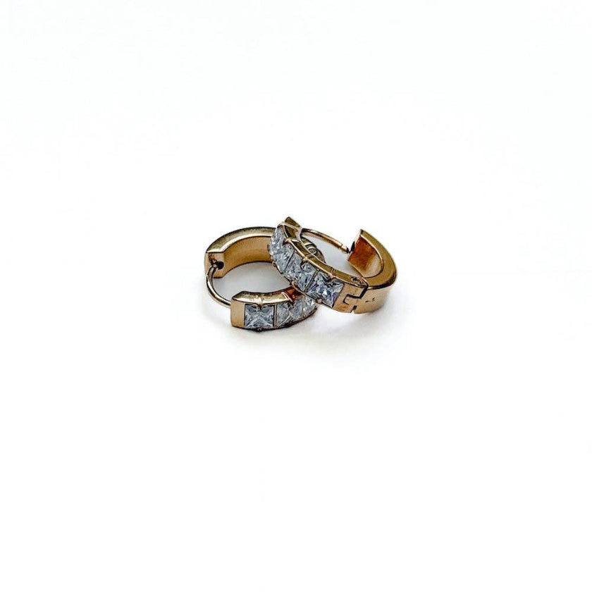 Gold hoop earrings with embedded stones on a white background