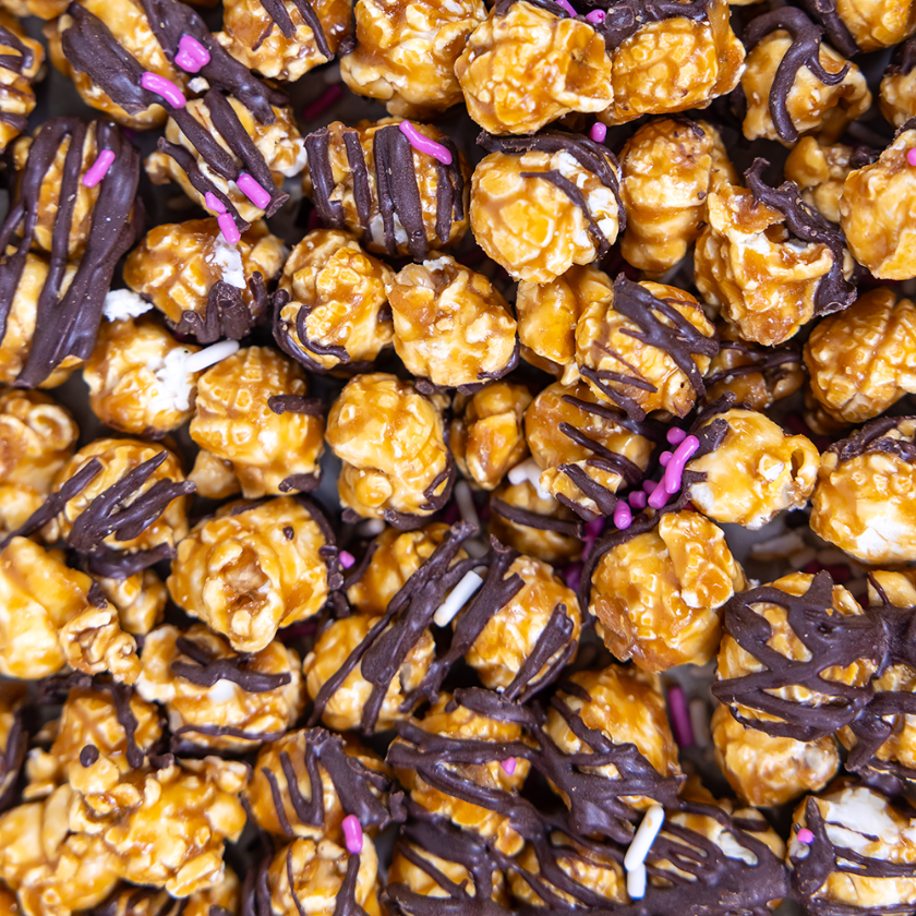 Caramel popcorn with chocolate drizzle and sprinkles.