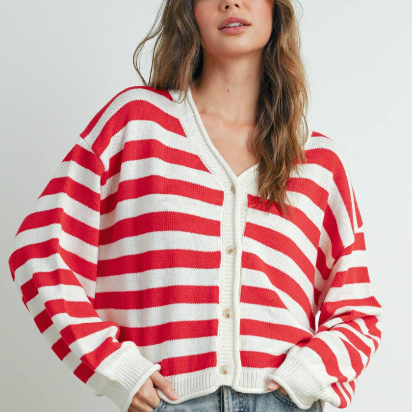 Woman wearing a red and white striped cardigan on a plain background