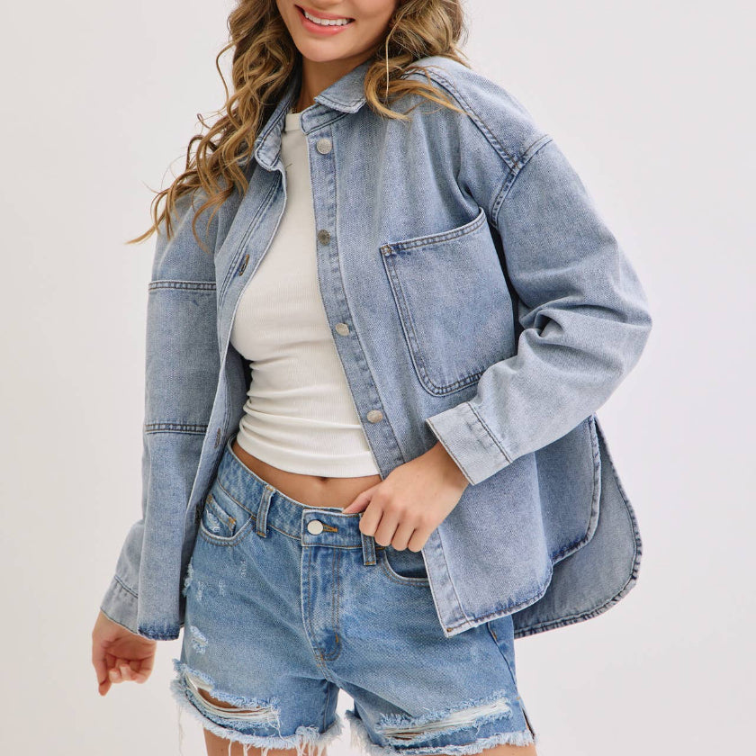 Woman wearing a denim jacket and shorts on a white background