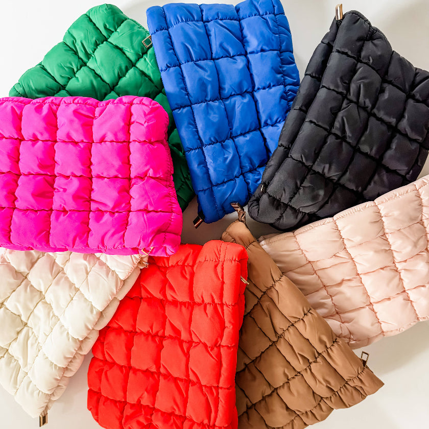 Collection of colorful quilted pouches on a white background