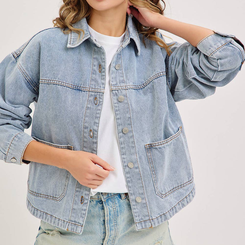 Woman wearing a light blue denim jacket and shorts on a white background