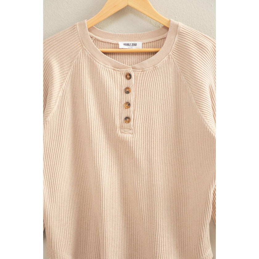 Beige ribbed henley shirt on a hanger with a plain background