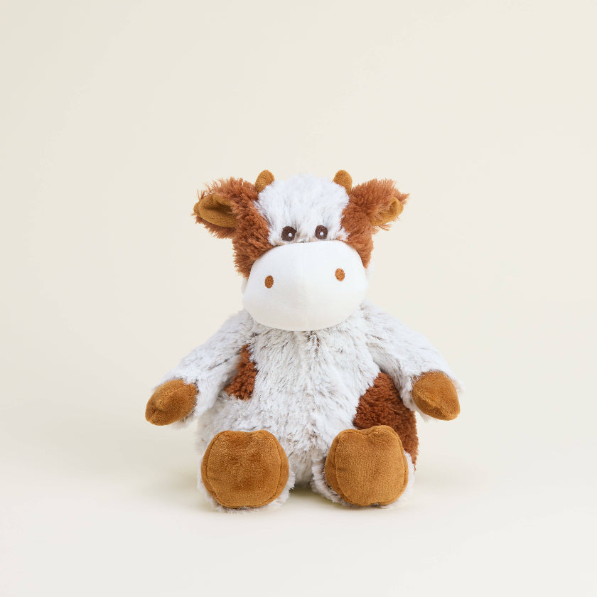 Plush cow toy on a beige background