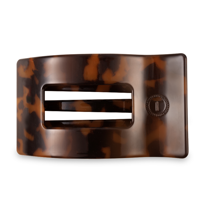 Tortoiseshell belt buckle with a silver bar on a white background