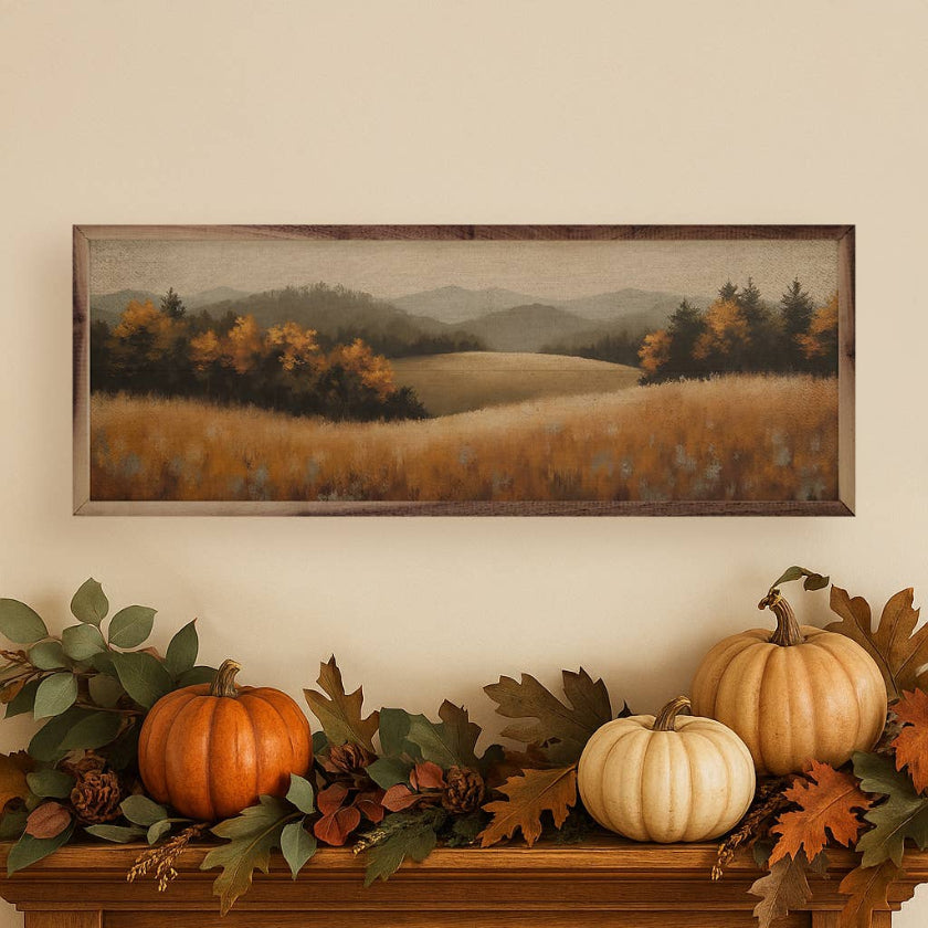 Decorative mantel with pumpkins and leaves, featuring a framed landscape painting on the wall.