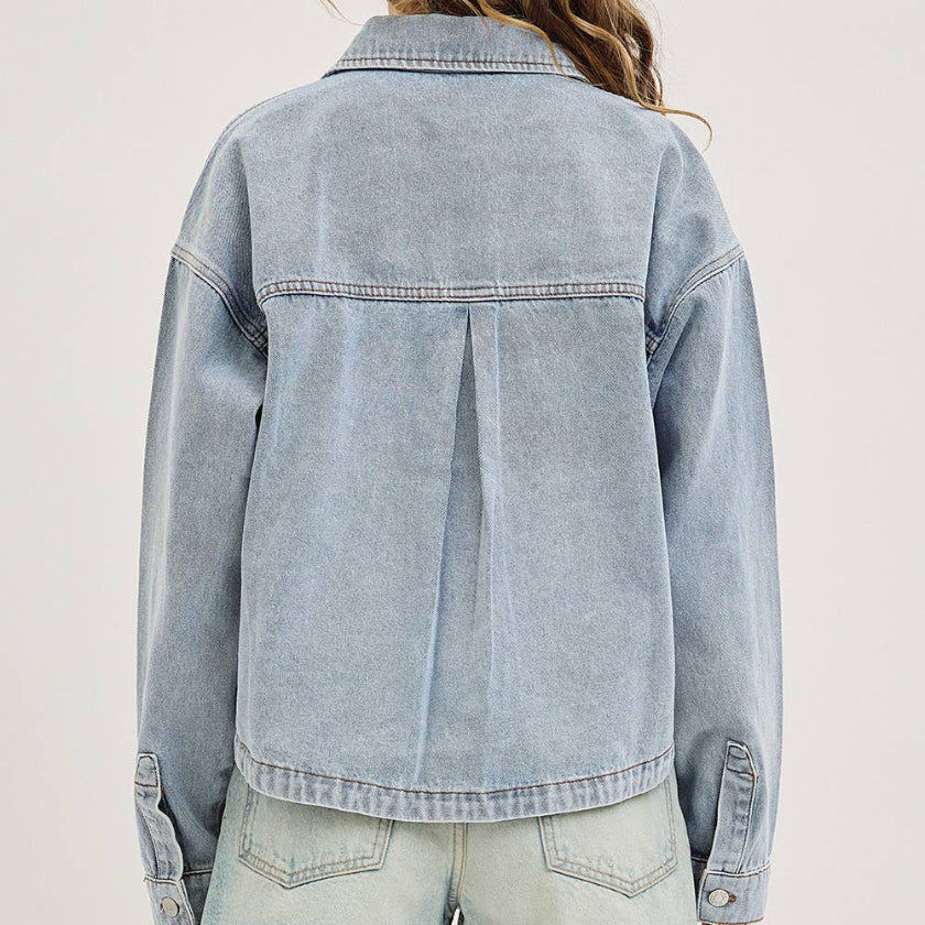 Light blue denim jacket worn by a person on a plain background