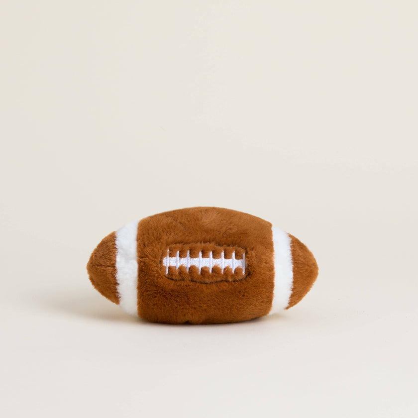 Plush football toy on a beige background