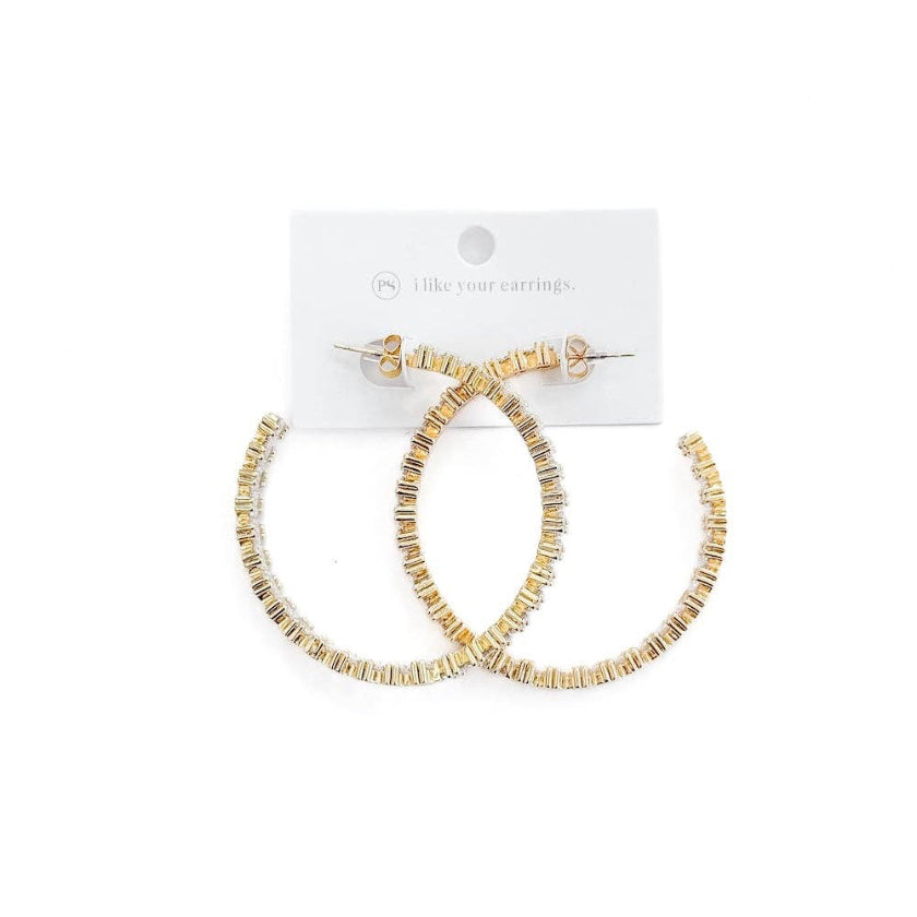 Gold hoop earrings on a white background with a visible brand label.