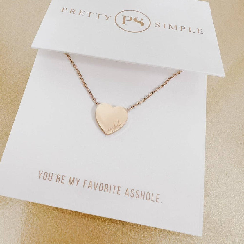 Rose gold heart-shaped necklace on a 'Pretty Simple' card with humorous text.