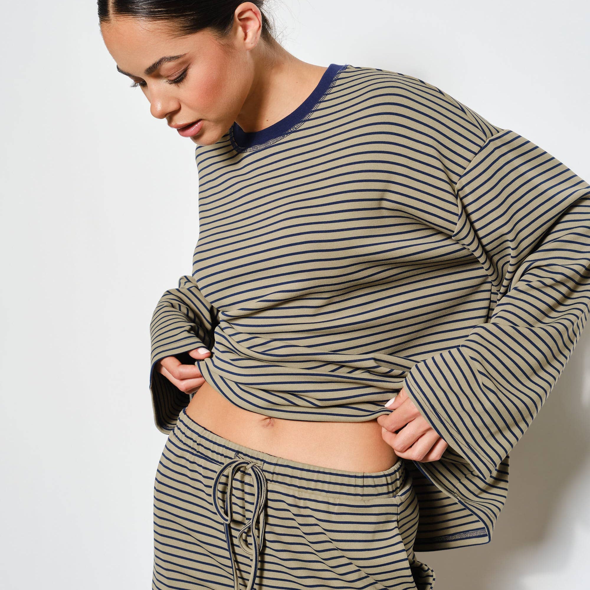 Woman wearing a striped outfit with a white background