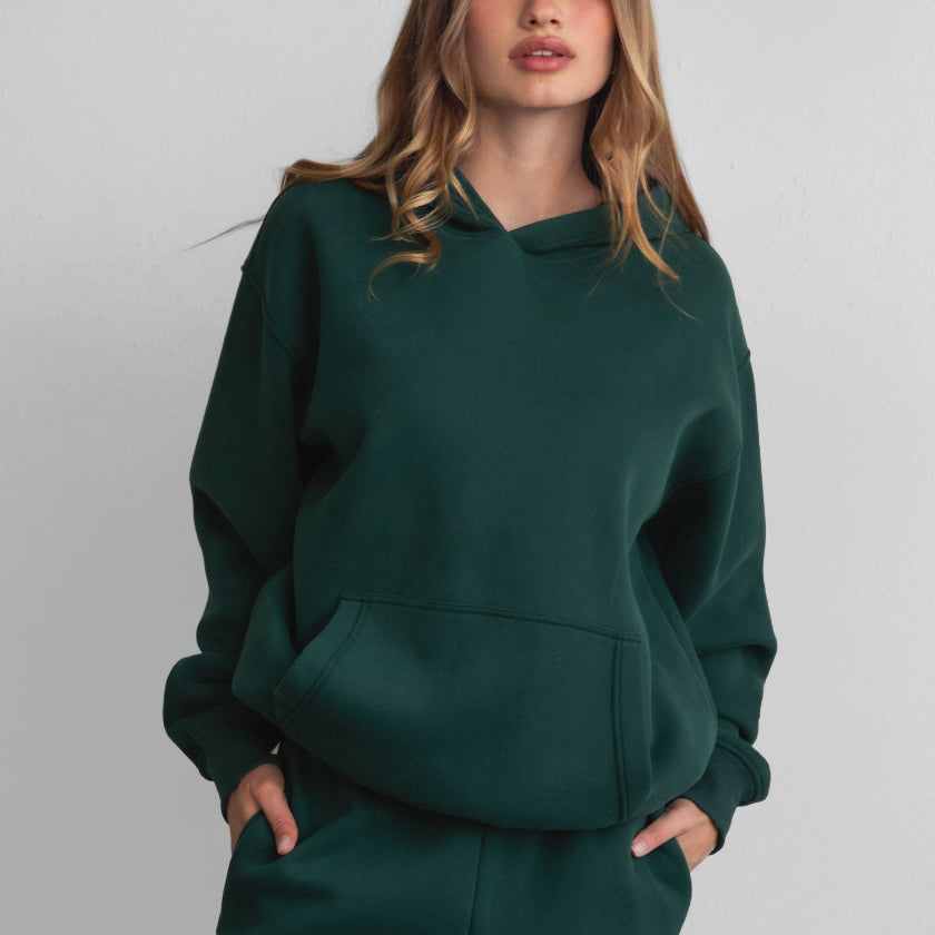 Woman wearing a green tracksuit against a plain background