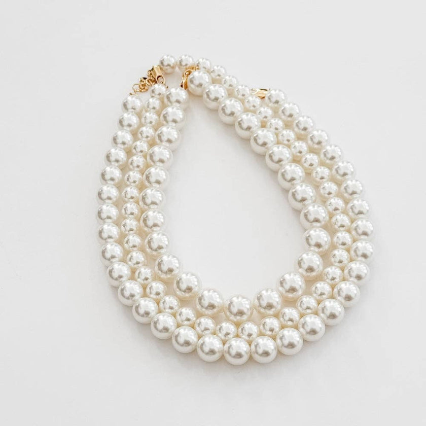 Multi-strand pearl necklace on a light gray background