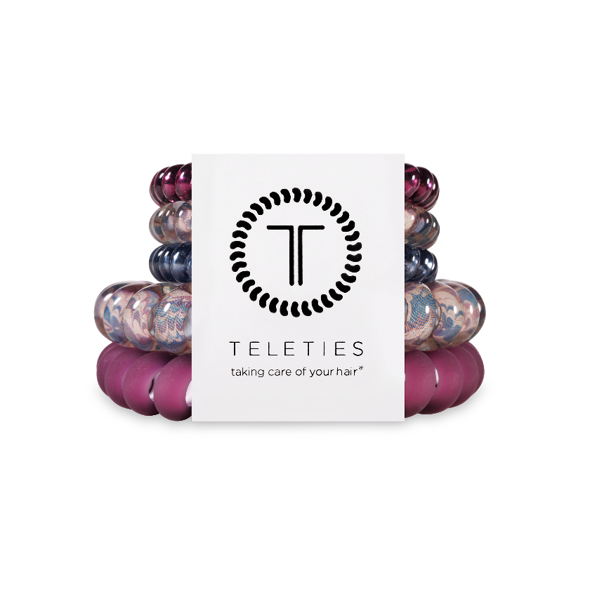 Stack of colorful hair ties with a white card displaying 'Teleties' brand on a white background