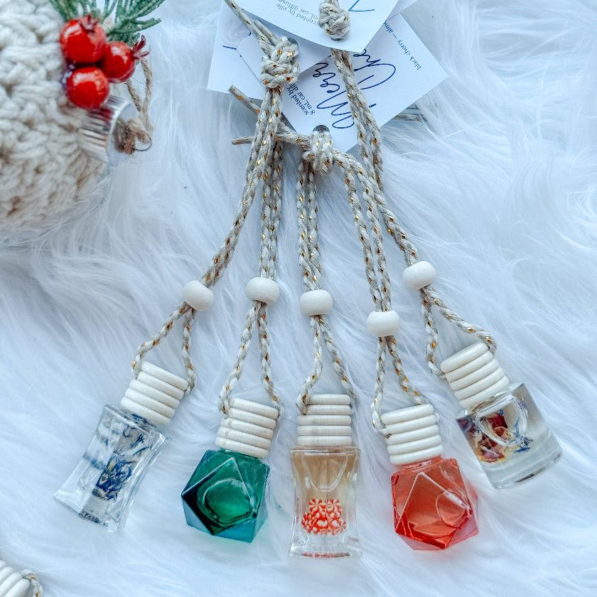 Set of decorative bottles with crystal stoppers on a textured white surface