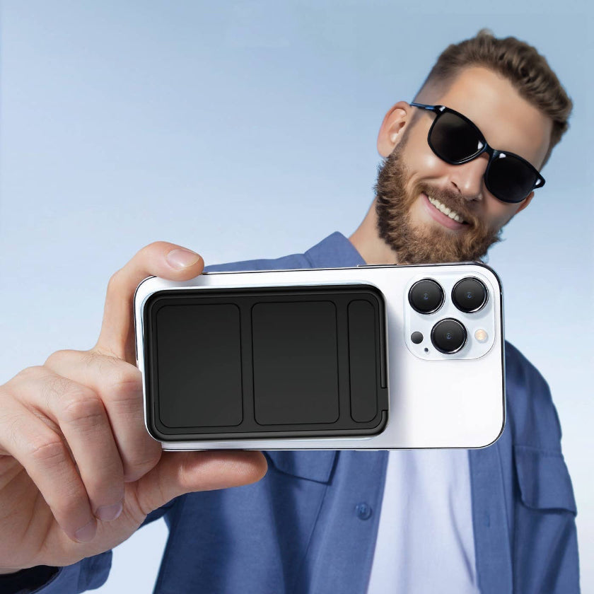 Man holding a smartphone with a clear case against a light blue background