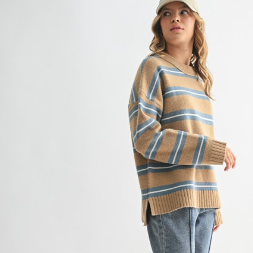Woman wearing a striped sweater and cap on a white background