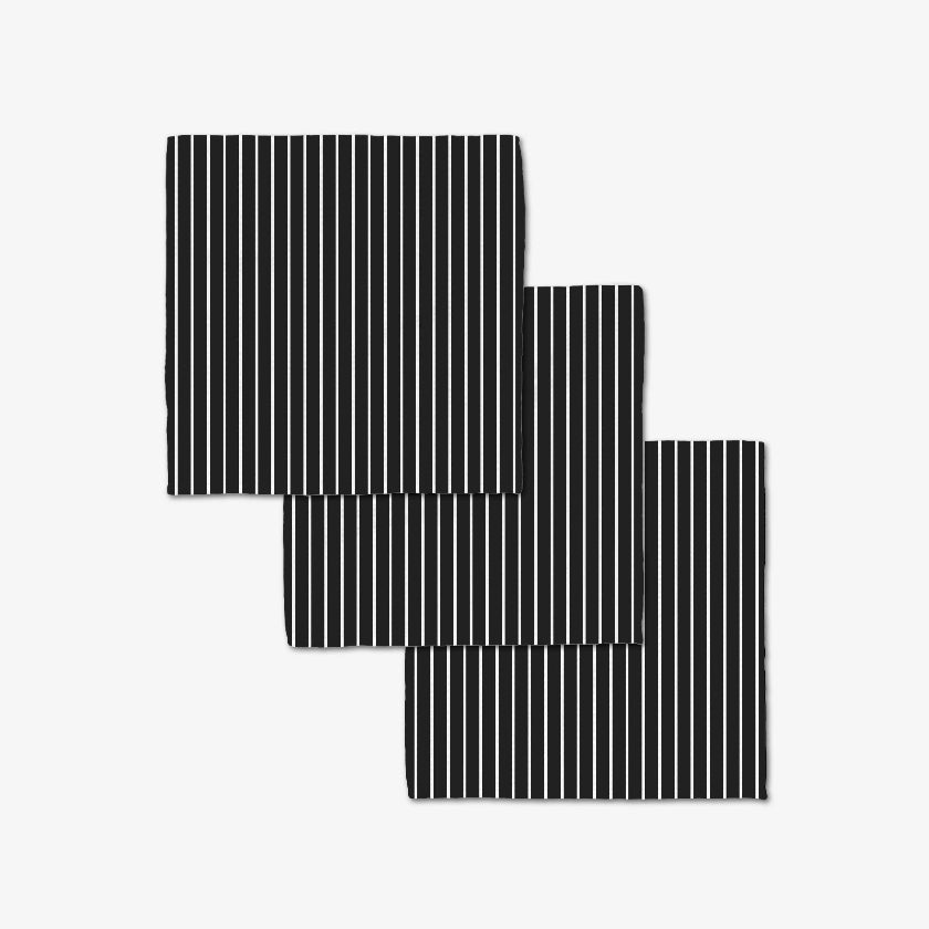 Set of three black and white striped placemats on a light gray background