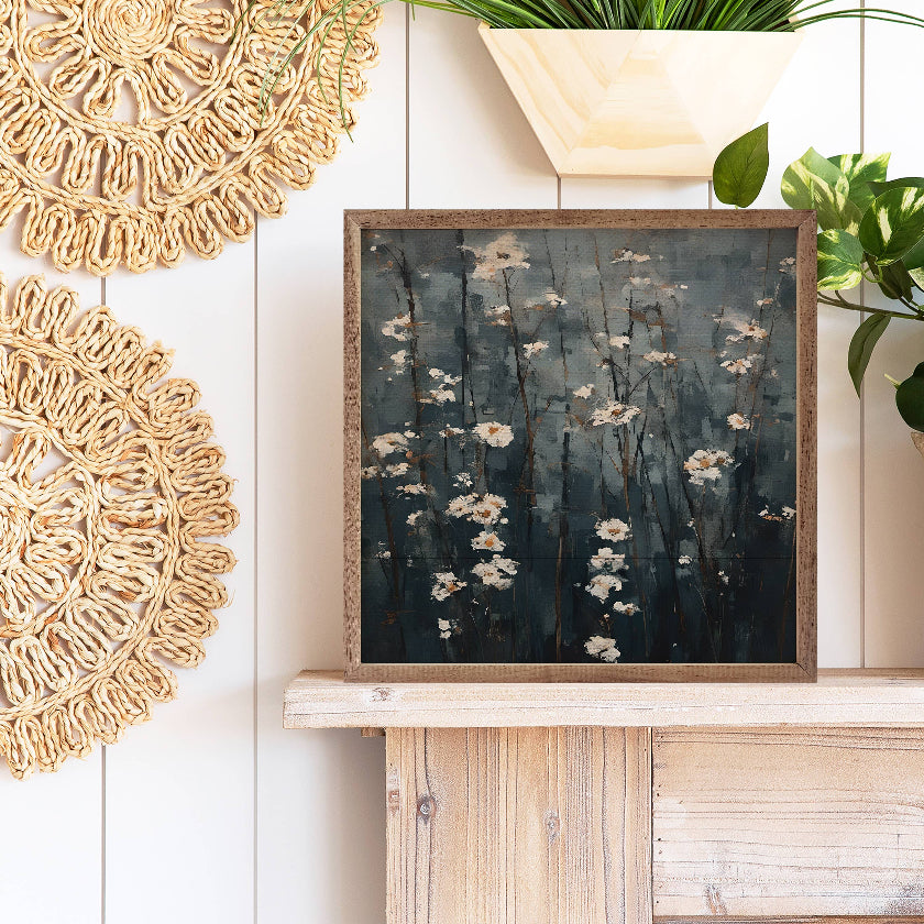 Decorative wall art with floral design on a wooden shelf, surrounded by plants and decorative items.