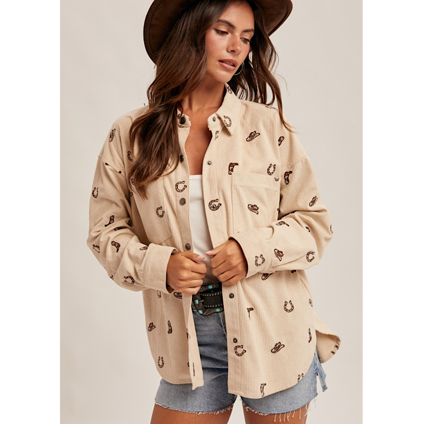 Woman wearing a beige patterned shirt with a plain background