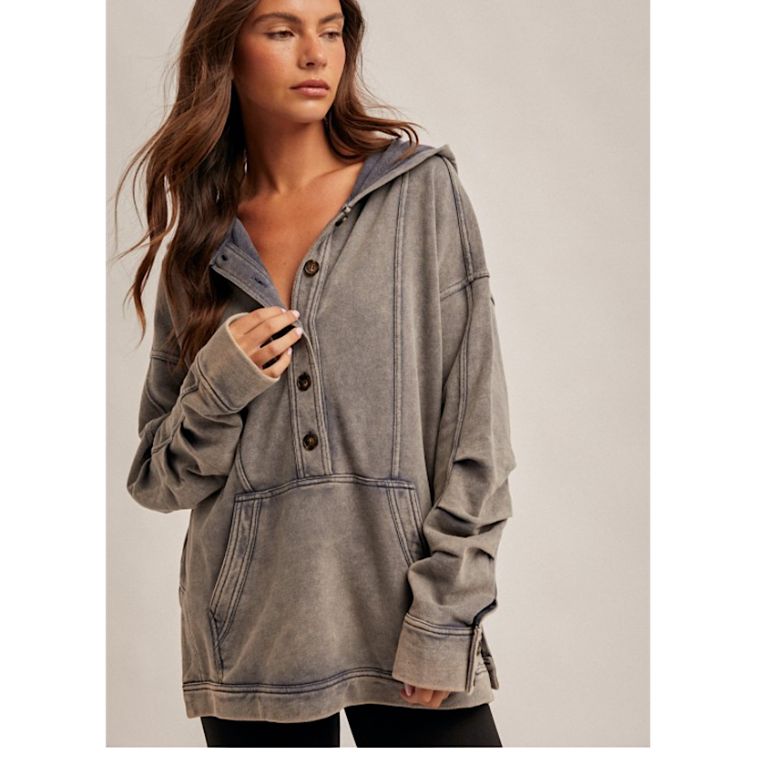 Woman wearing a gray hooded jacket on a plain background