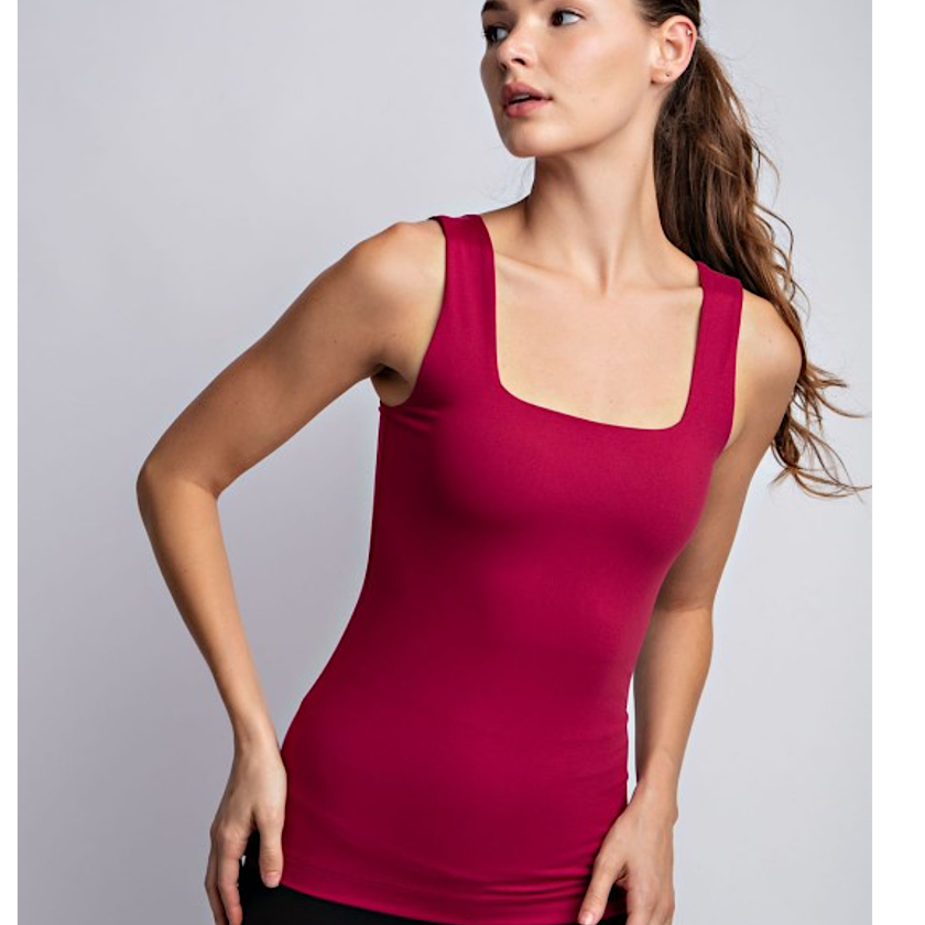 Woman wearing a red tank top against a gray background