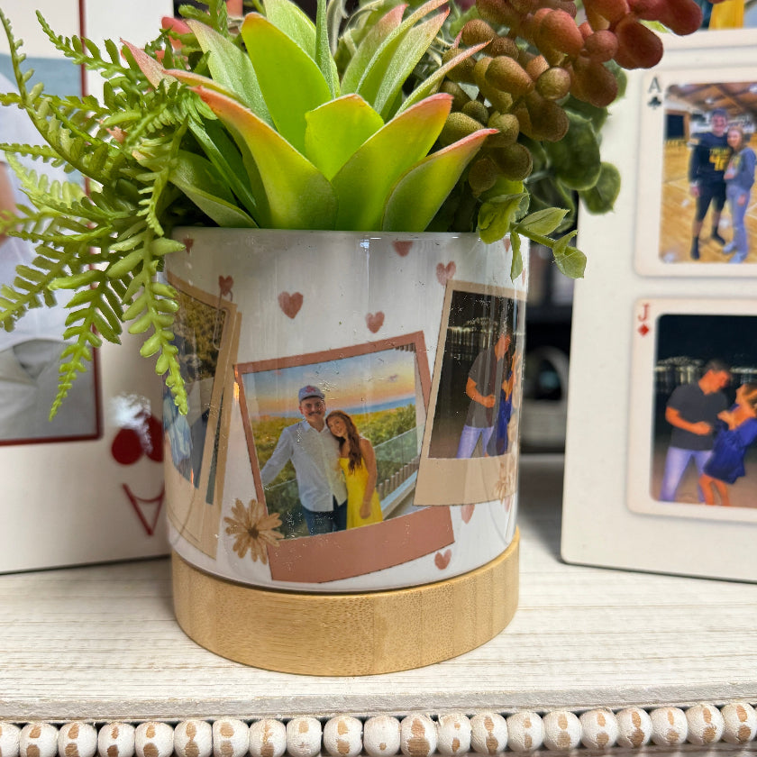 Decorative candle with a plant on top, featuring artistic designs on the packaging.