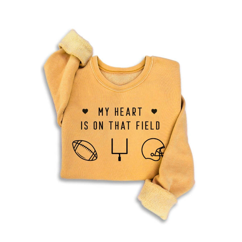 Yellow sweatshirt with text 'My heart is on that field' and sports icons on a white background