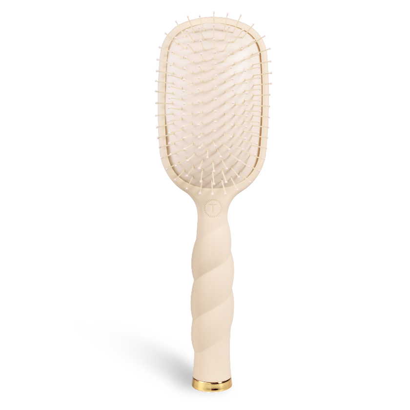 Beige paddle hairbrush on a white background