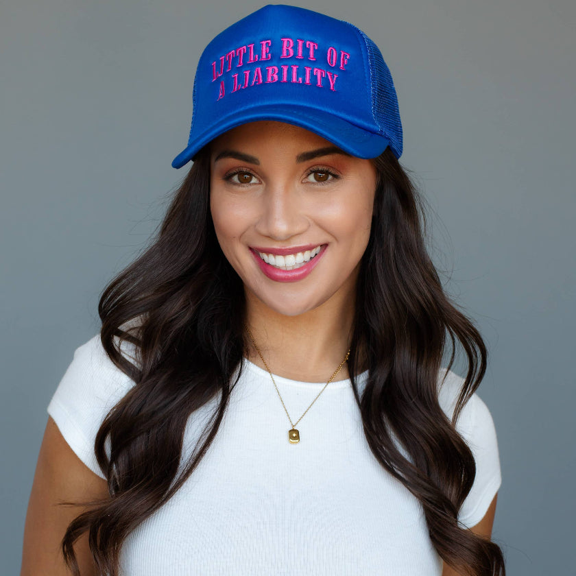 Woman wearing a blue cap with pink text against a gray background
