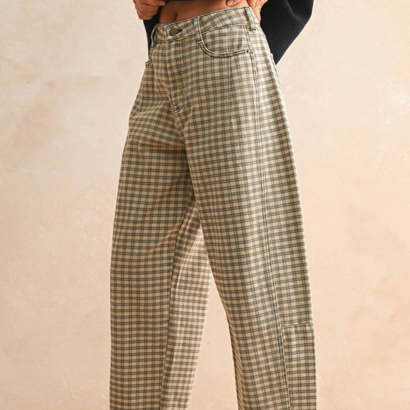 Person wearing plaid pants and brown shoes on a beige background