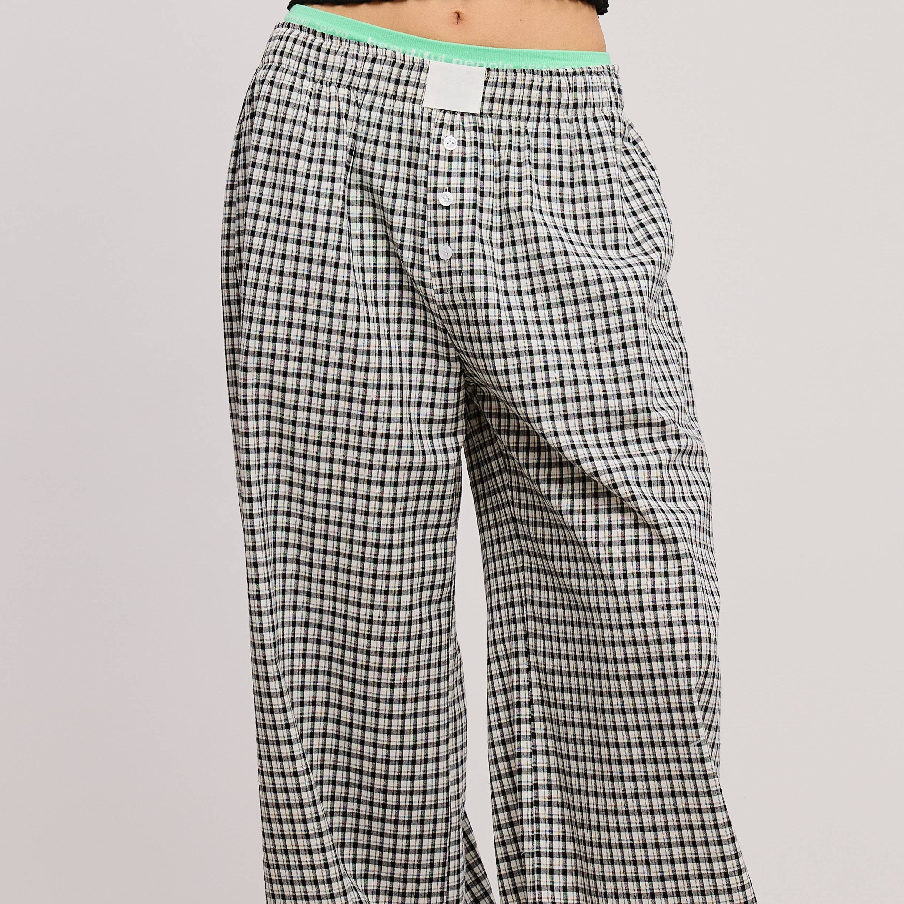 Plaid pajama pants with green accents on a plain background