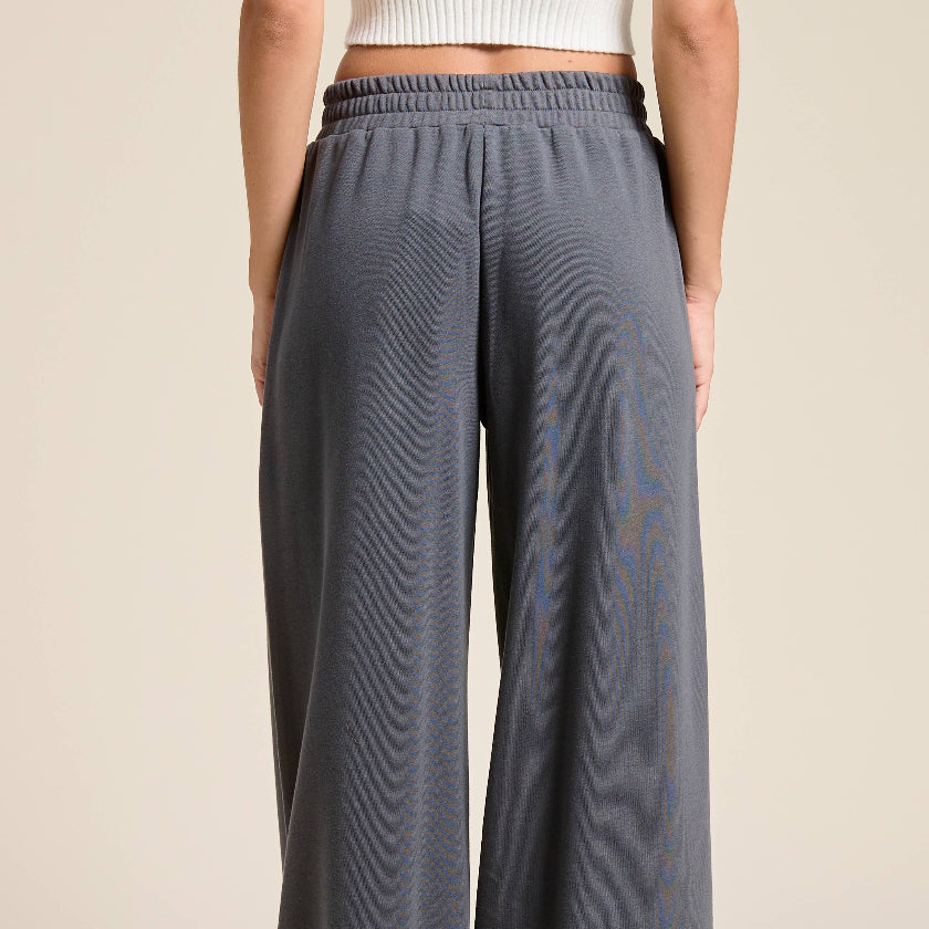 Gray wide-leg pants worn by a person on a beige background