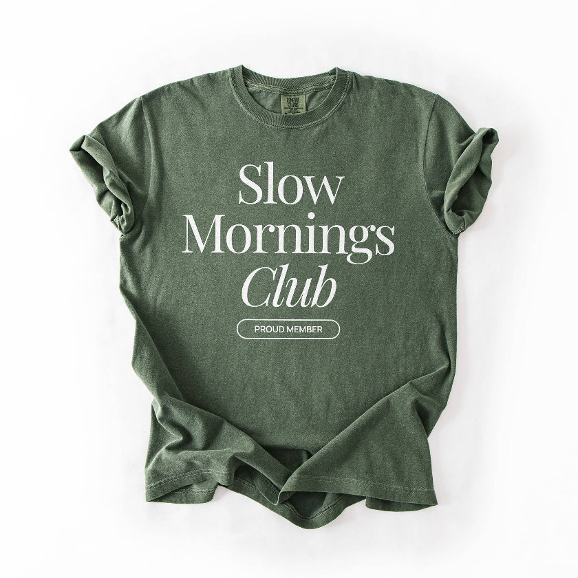Green t-shirt with 'Slow Mornings Club' text on a white background