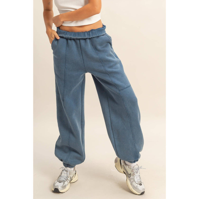 Person wearing blue sweatpants on a beige background