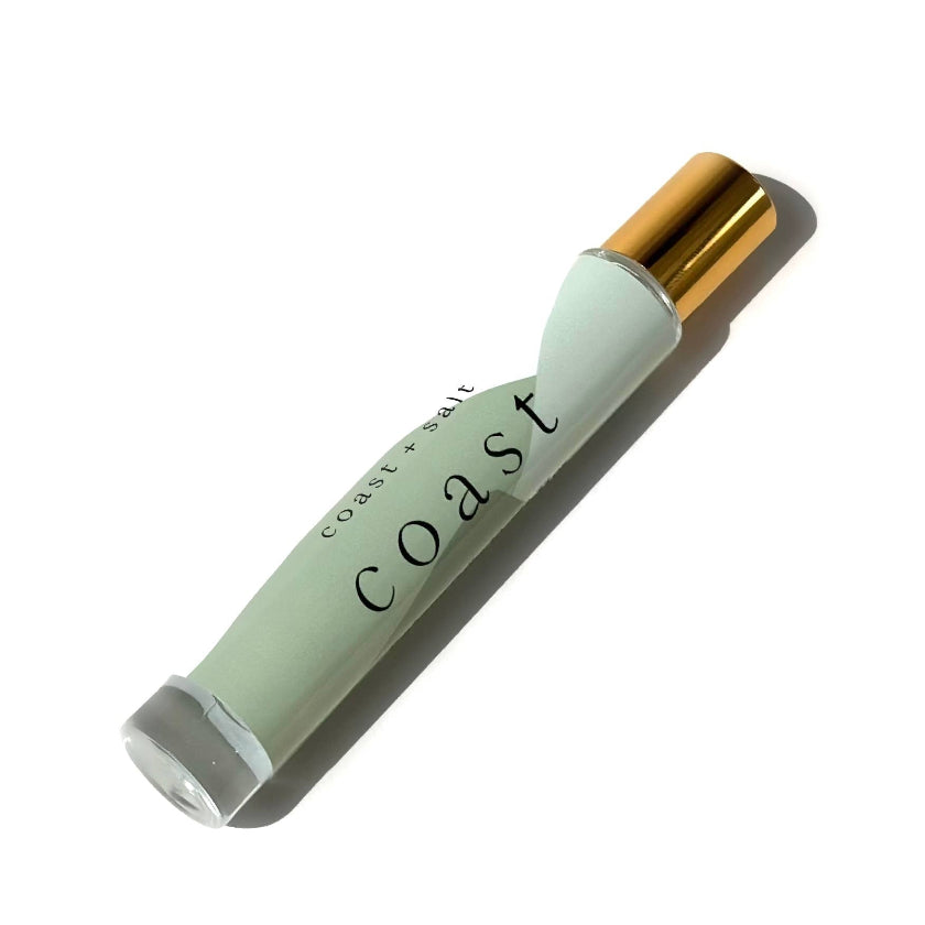 Mint green and gold lip balm with 'Coast' branding on a white background