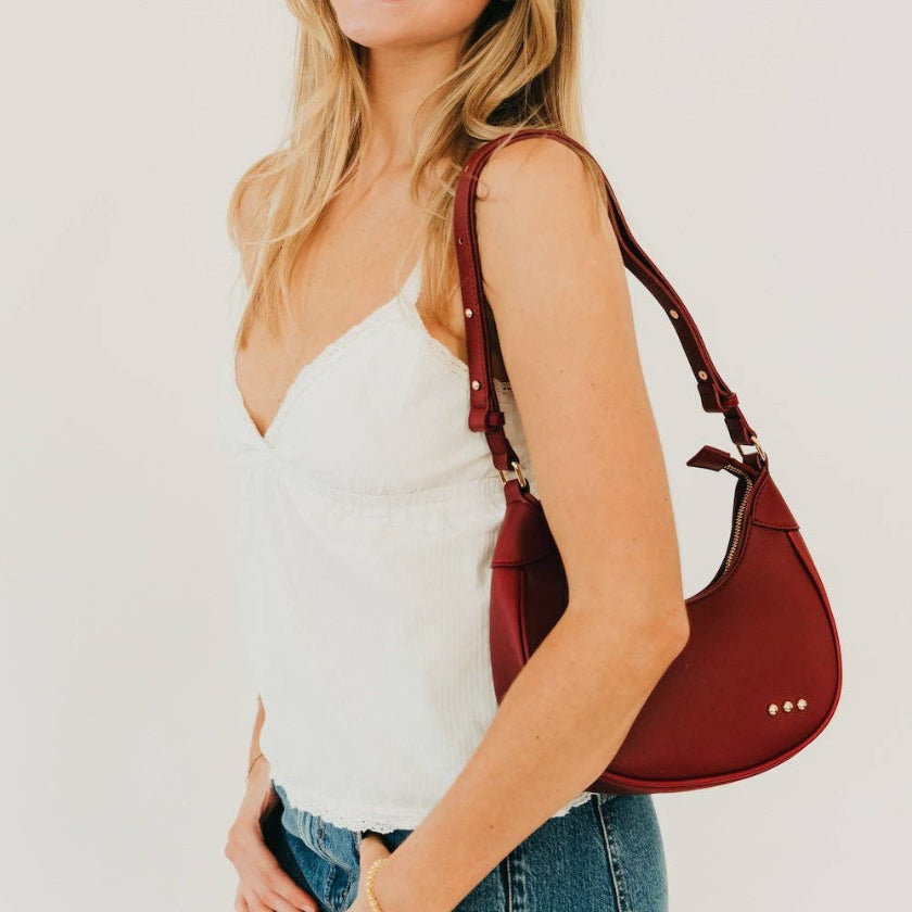 Woman holding a red handbag against a white background