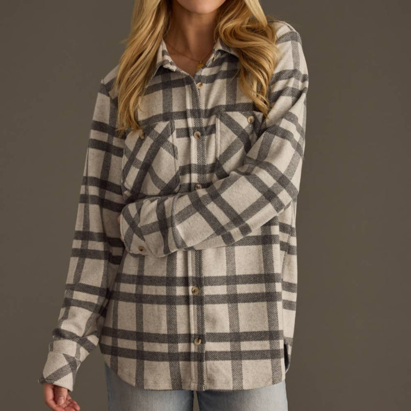 Woman wearing a plaid shirt against a plain background