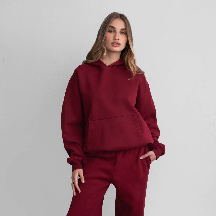 Woman wearing a red tracksuit against a plain background