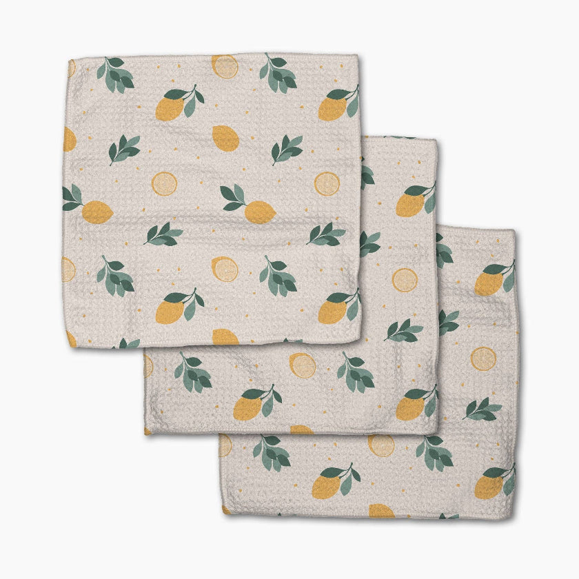 Set of three folded towels with lemon pattern on a white background