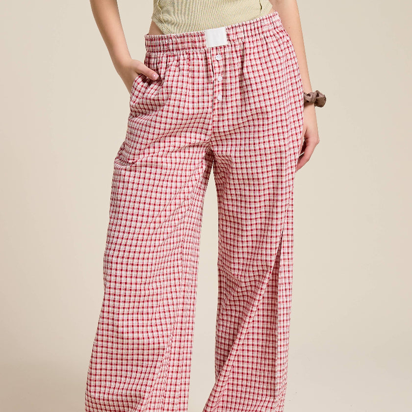 Person wearing red and white checkered pants on a beige background