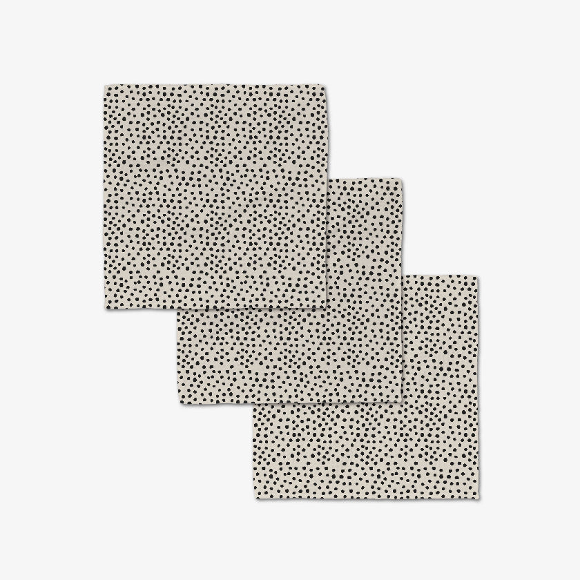 Three black and white patterned placemats on a light gray background