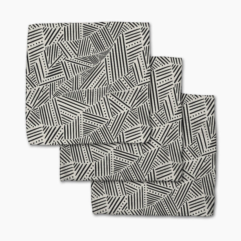 Set of four black and white patterned placemats on a white background