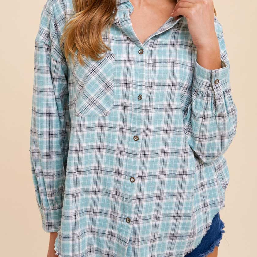 BUTTON UP PLAID SHIRT FEATURES BREAST POCKET AND RAW HEM.
