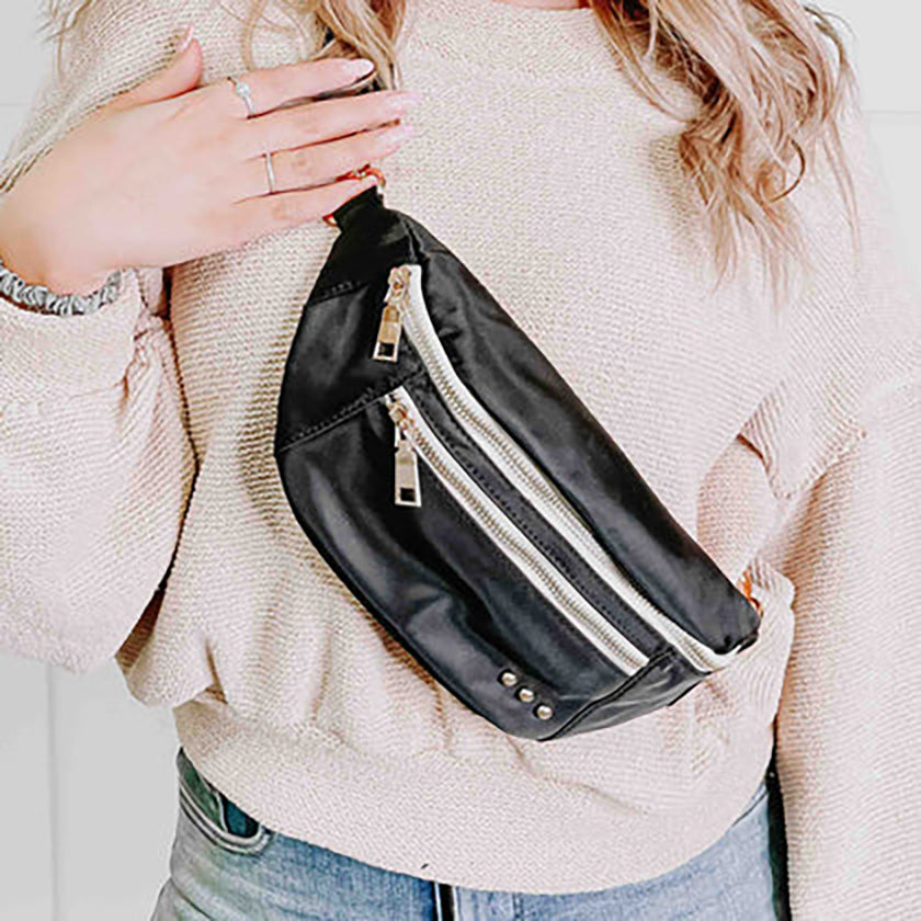 The Blakely Bum Bag in Black is a nylon bag that has an adjustable and removable strap, and can be worn either across your body or around your waist. It has two exterior zipper pockets, one to hold your smaller items and the other to hold your larger items. 