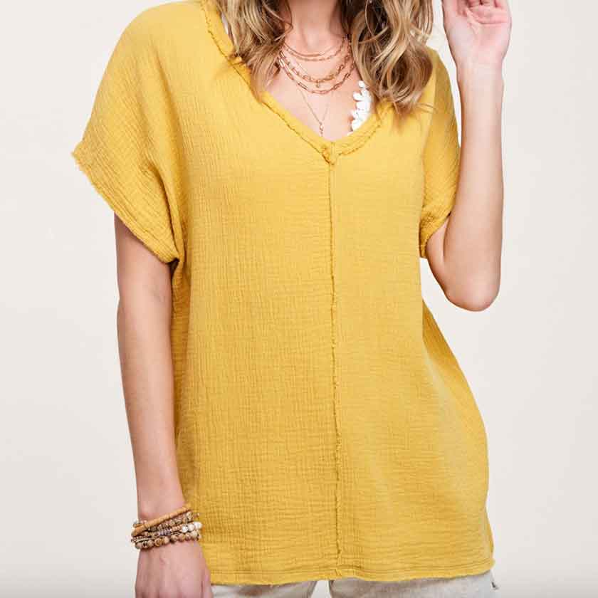 V-neck cotton gauze, in dry mustard, top with raw edge details and side slits at the bottom and high-low bottom hem.
100% COTTON