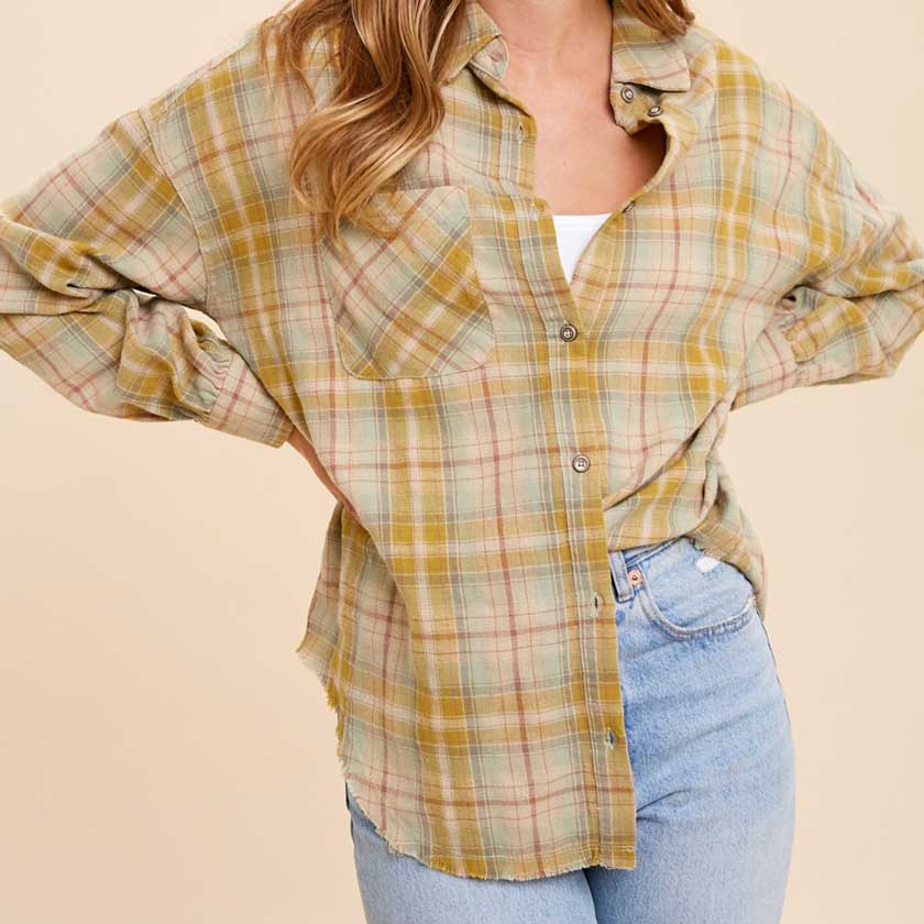 BUTTON UP PLAID SHIRT FEATURES BREAST POCKET AND RAW HEM.